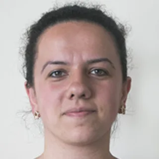 Headshot of a woman with dark hair against a plain light background.