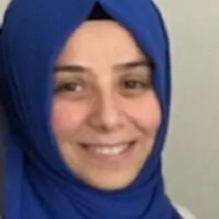 Close-up portrait of Yasemin Çetin wearing a blue headscarf and smiling gently.