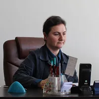 Dilek Uzem is seated at her office desk in a professional workspace.