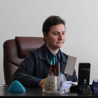 Dilek Uzem is seated at her office desk in a professional workspace.