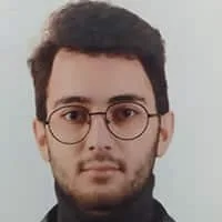 Portrait of Alp Çayıroğlu wearing glasses and a dark top.