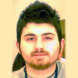 Close-up portrait of Emrah Altun looking directly at the camera with short dark hair and light facial hair.