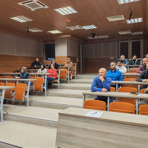 Yapay zekâ okuryazarlığı seminerinde konferans salonunda oturan katılımcılar.