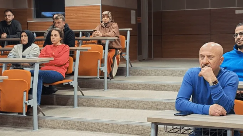 Amfi sıralarında oturan seminer katılımcıları.