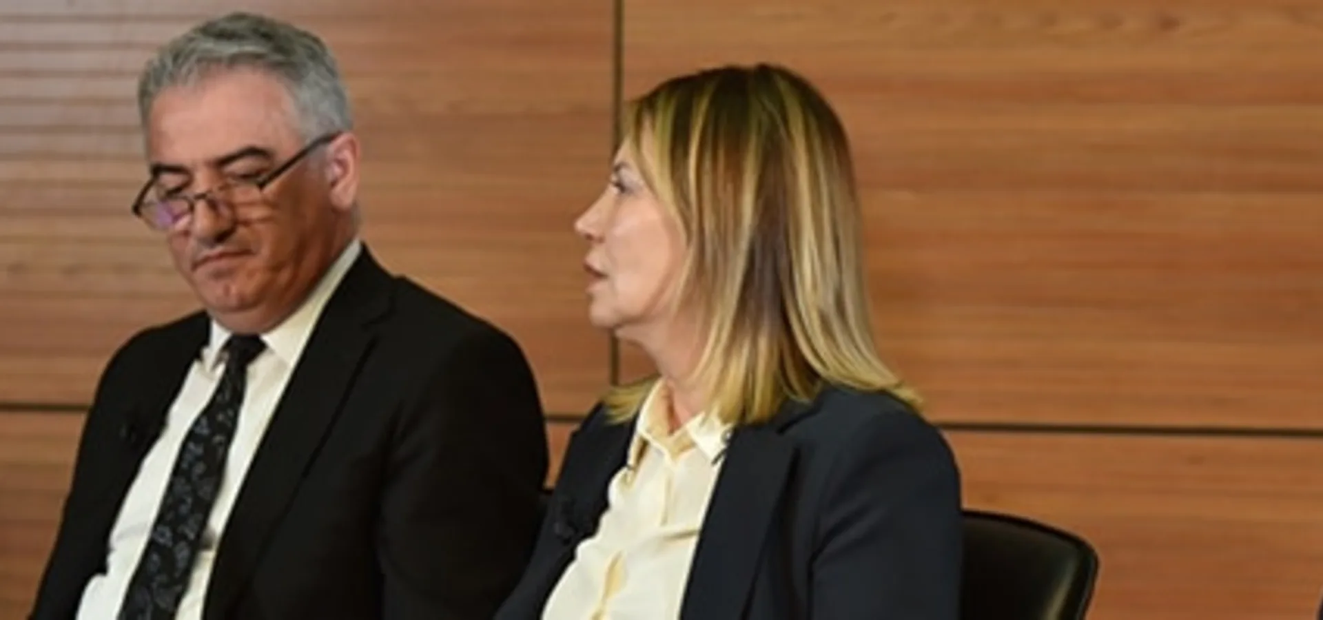 Four speakers sitting side by side on a panel.